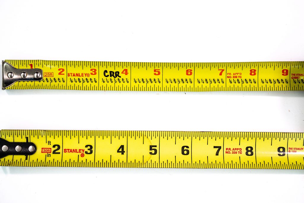 Image of two tape measures. One with and one without fractional markings