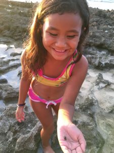 Child at seashore playing with seashell