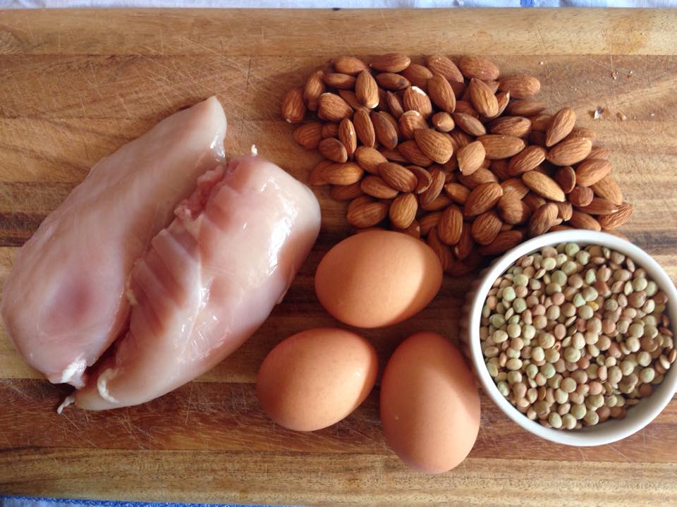 Chicken, eggs, and nuts on a carving board