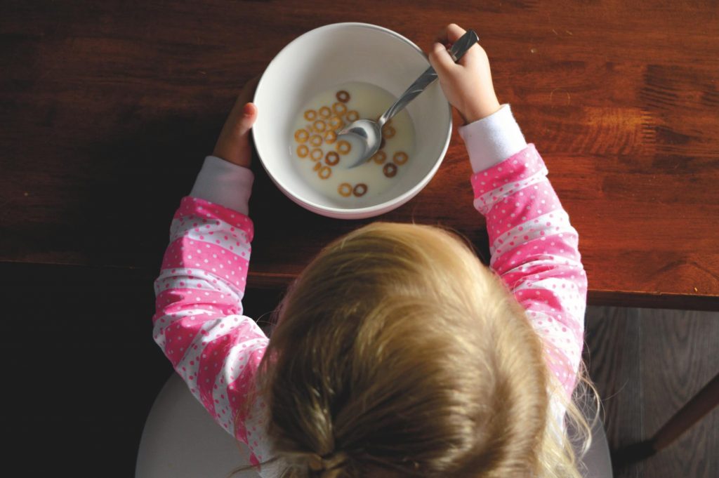 Child with a bowl of cereal and milk