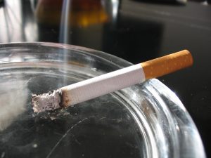 Lit cigarette resting on ashtray