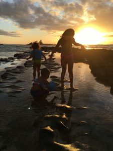 Children playing at the beach at sunset