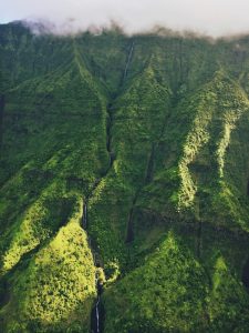 A landscape photo of green mountains top with clouds in Hawai’i